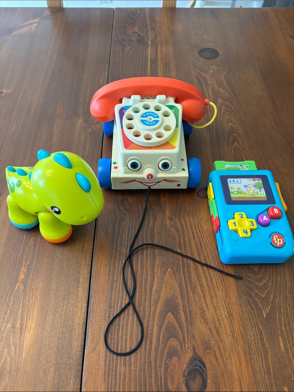 Fisher-Price Vintage Pull-Along Rotary Phone, Atari type play game, and Dino.
